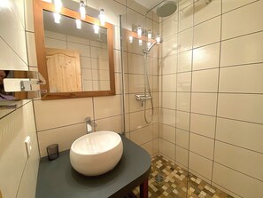 A bathroom with a round sink, a mirror, and a shower. - Cozy studio, mountain view - 4 guests (Méribel)