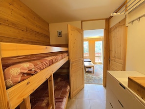 A wooden interior with a bunk bed, a small table, and a bench. - Cozy studio, mountain view - 4 guests (Méribel)