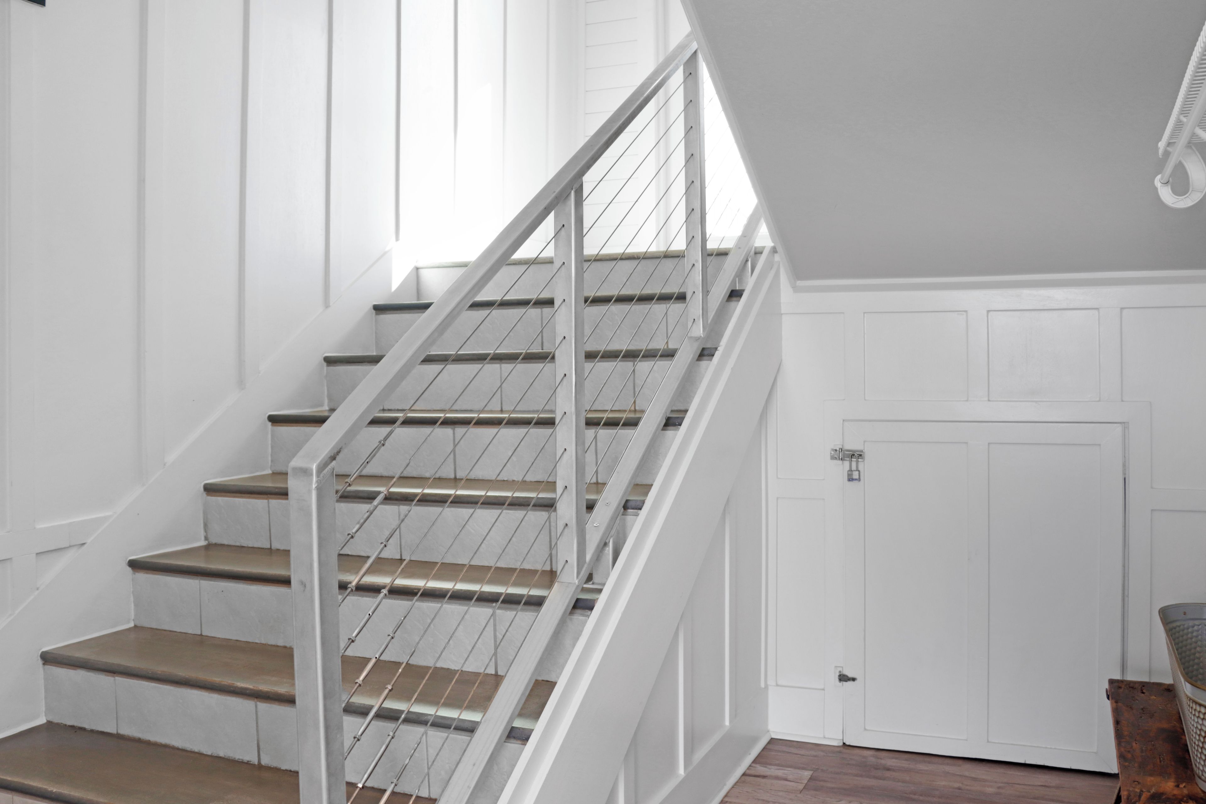 Un escalier avec des rampes en métal et des marches en bois menant à un palier.