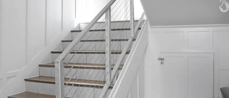 Un escalier avec des rampes en métal et des marches en bois menant à un palier.