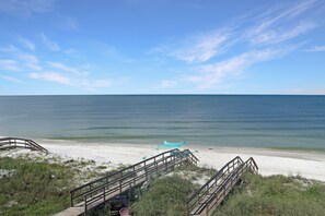 A beach with wooden boardwalks leading to the shore, a sandy beach, and the ocean. - 🌊Singing Waves | Stunning Beachfront | Community Pool | Pet Friendly (Cape San Blas)