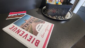 A brochure titled 'BIEUXVILLE' on a table, a 'BIENVENUE' card, and a 'Vacances Vertes' guide. - Charming apartment in city center - 2 guests (Luxeuil-les-Bains)