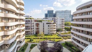 Un edificio residencial de varios pisos con balcones, un patio central con vegetación y arquitectura moderna.