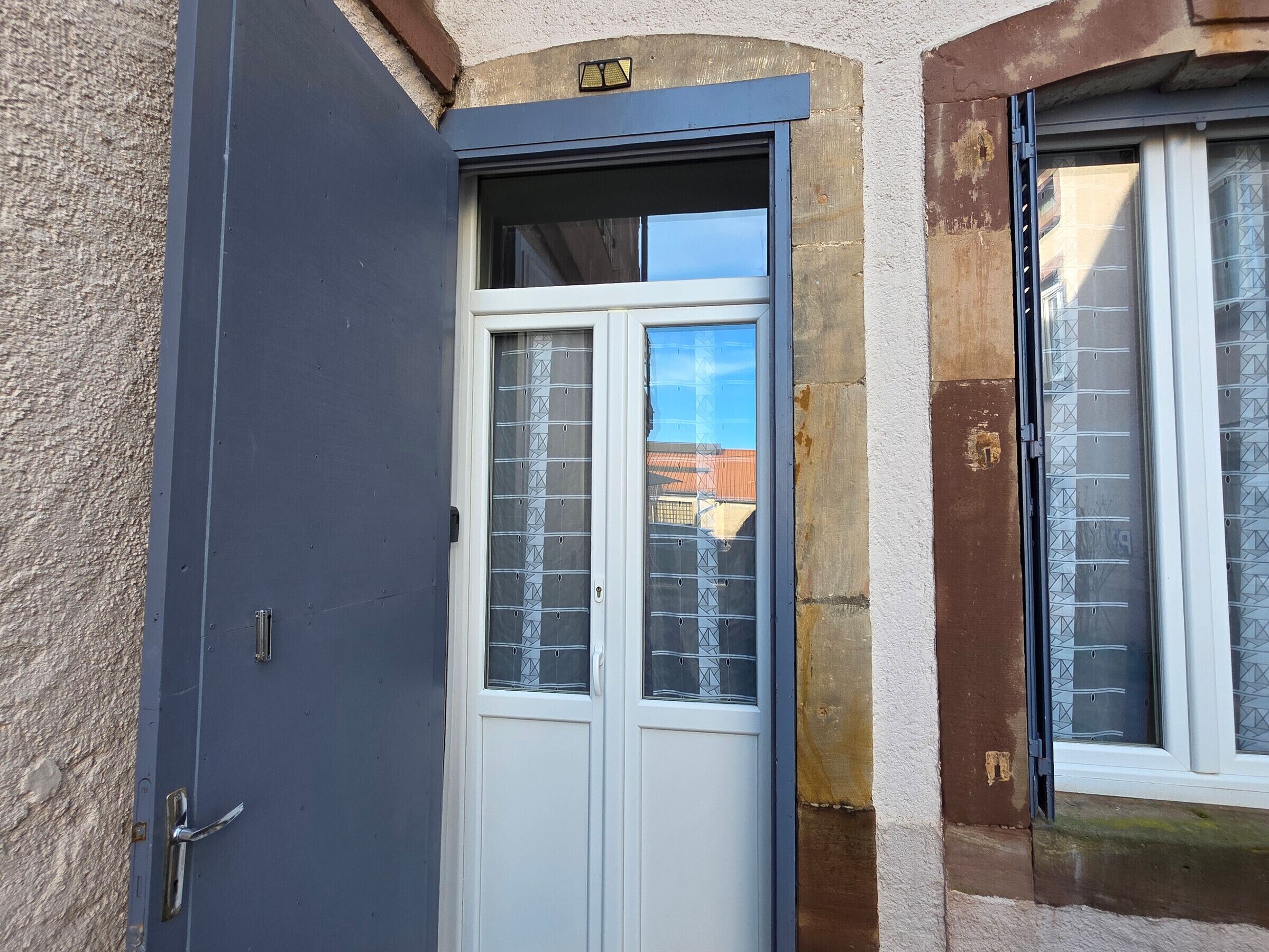 A door with a window, a visible lock, and a small window to the right.