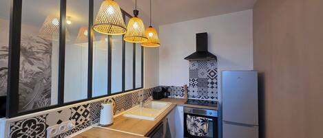 A modern kitchen with a wooden countertop, a built-in oven, and a black range hood.