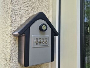 Ein elektronisches Tastaturschloss an einer strukturierten Wand.