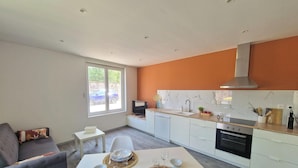 A modern kitchen with a dining area, a large window, and a view of the outside. - Renovated cottage near thermal baths (Luxeuil-les-Bains)