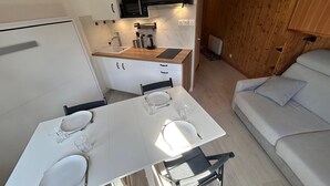 A compact kitchen with a microwave, stove, and wooden cabinets. - Cozy apartment with balcony - 4 guests (Avoriaz)