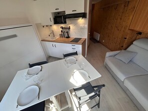 Eine kleine Küche mit Mikrowelle, Herd und Holzschränken.