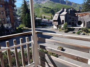 Ein Bergdorf mit Holzhäusern und freiem Blick auf die umliegende Landschaft.