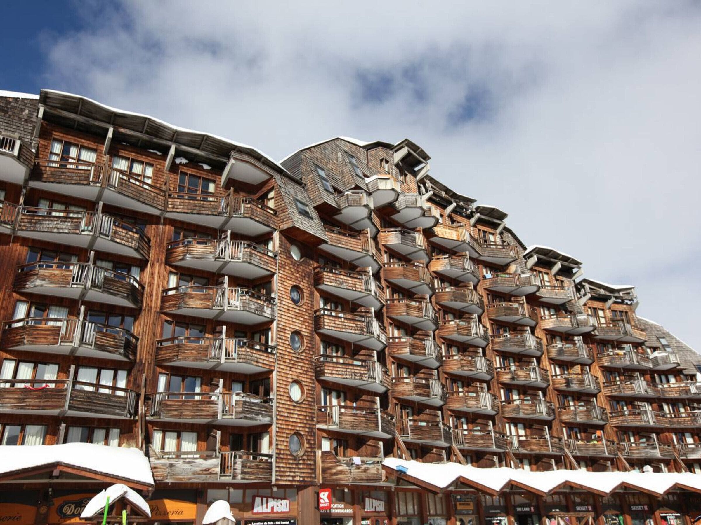 A multi-story hotel with balconies and a wooden facade.