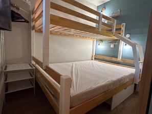 A bunk bed with a wooden frame, a white mattress, and a small shelf unit beside it. - 2-room apartment - 5 guests, ski-in/ski-out (Avoriaz)