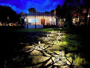 A building with a patio area, outdoor seating, and a pathway with decorative elements.