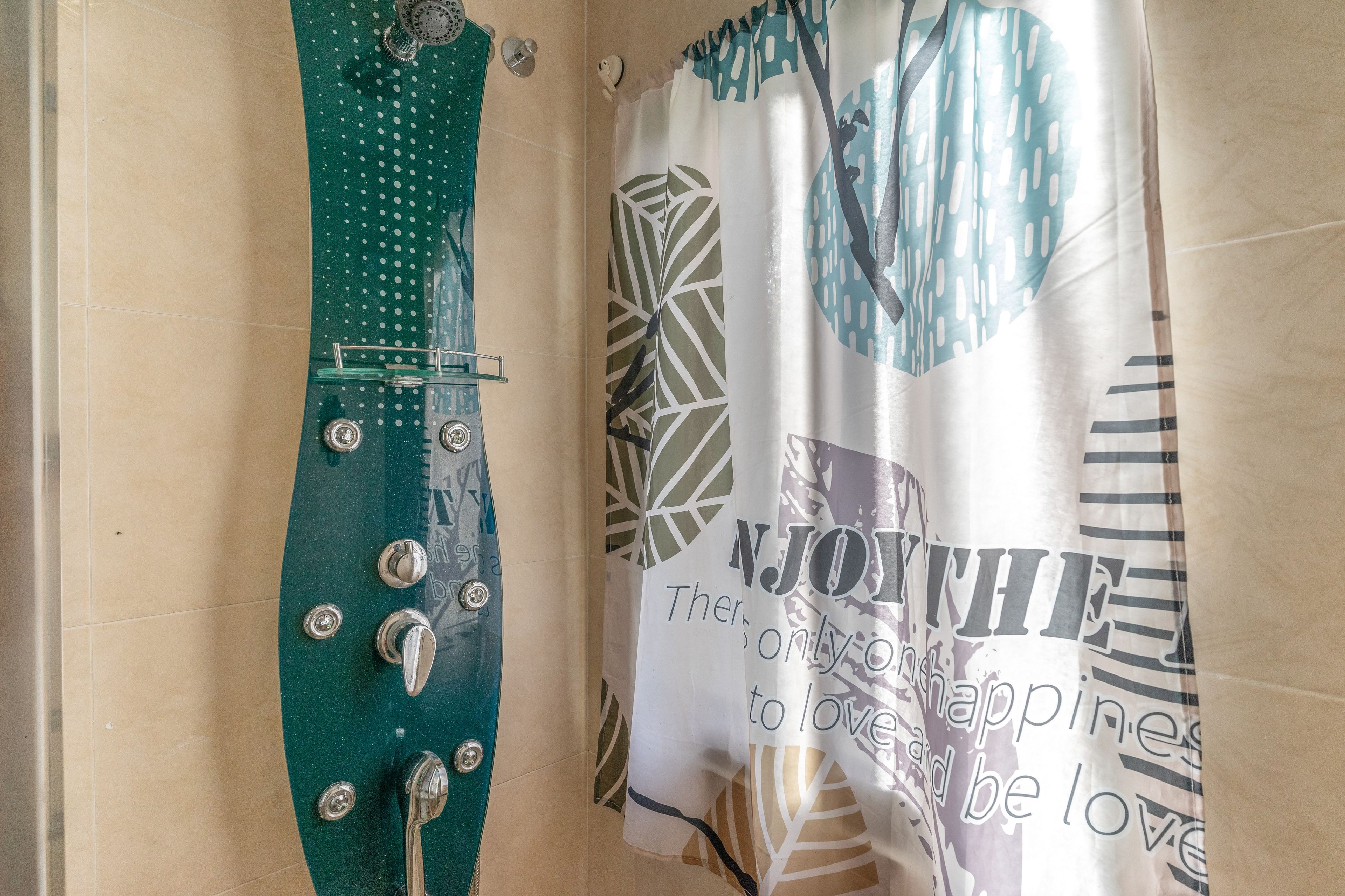 Un baño con cortina de ducha verde y una estampada.