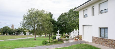Il s’agit d’une propriété résidentielle à l’extérieur blanc, dotée de fondations en pierre, d’un jardin à l’avant avec une fontaine blanche et surplombée d’un ciel dégagé.