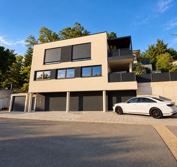 Un bâtiment moderne à deux étages, avec une voiture garée devant.