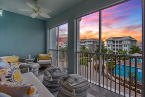 A balcony with a view of a swimming pool and buildings during sunset. - Sister’s Paradise by AMI Locals (Bradenton)