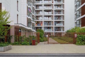 A multi-story residential building with balconies, a gated entrance, and a paved walkway. - Luxury Apartment in Chmielna Duo |Air Conditioning (Warszawa)