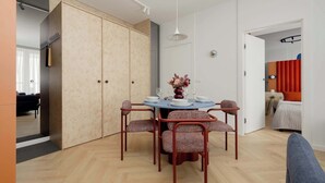 Een moderne eetruimte met een ronde tafel, vier stoelen en een vaas met bloemen.