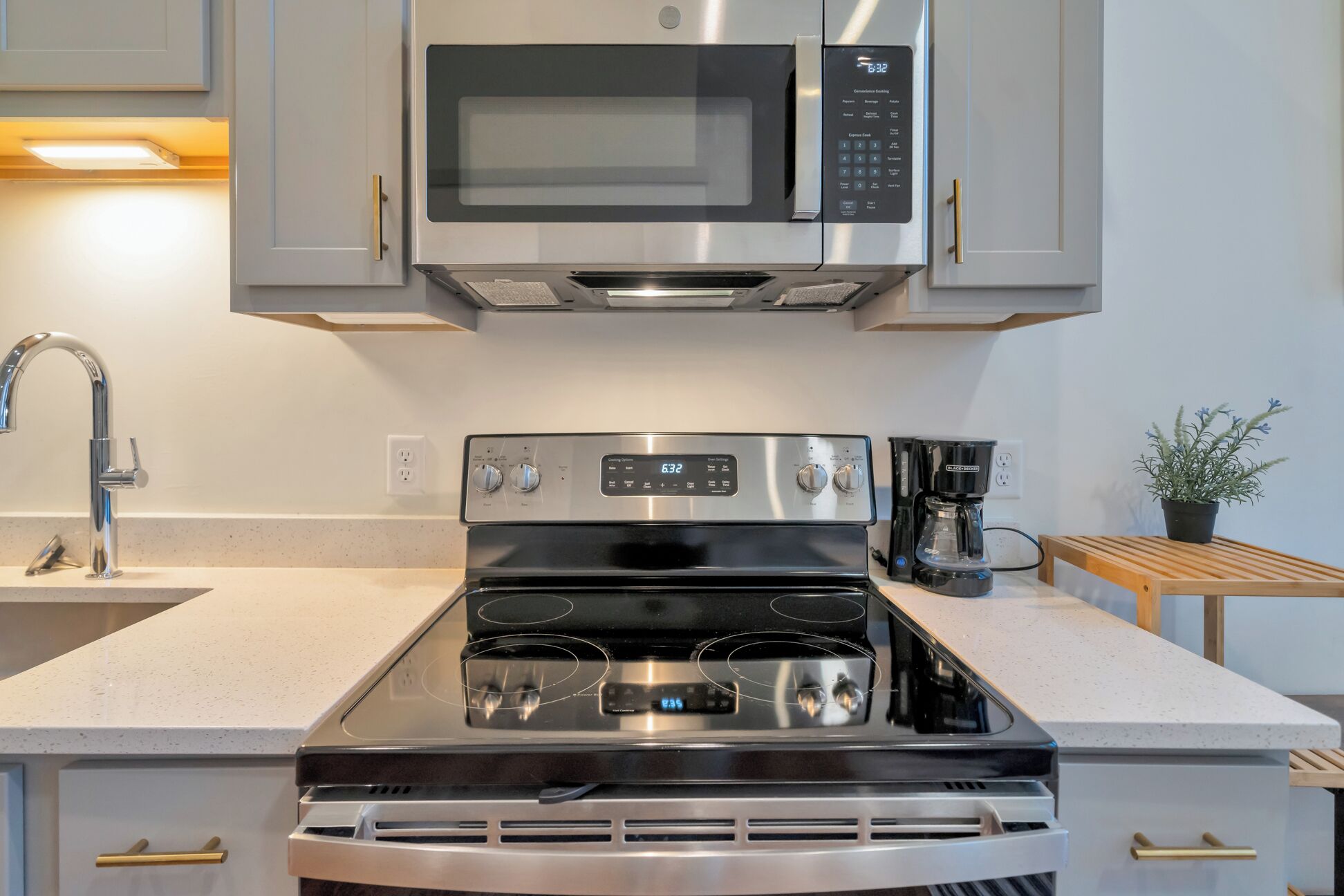 A kitchen with stainless steel appliances, including a microwave, oven, and coffee maker.