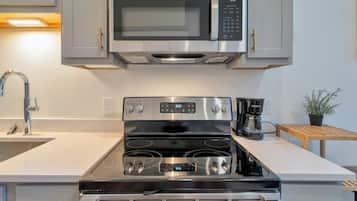 A kitchen with stainless steel appliances, including a microwave, oven, and coffee maker.