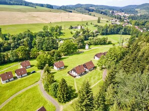 Un village rural où les maisons sont entourées de verdure et de champs.