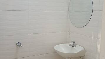 A bathroom with a shower, a sink, and a mirror.