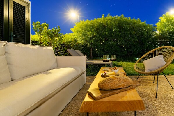 An outdoor seating area with a sofa, a dining table with bread and drinks, and a chair. - Villa Catalina, just a short walk from the beach in San Agustín (San Bartolomé de Tirajana)