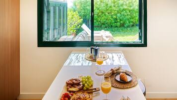 Een ontbijttafel met croissants, druiven en een glas sinaasappelsap.