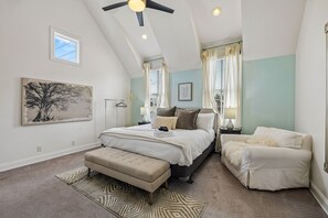 A bedroom with a bed, a bench, a nightstand, a ceiling fan, and a window. - Spacious Nashville townhouse w/ exclusive backyard (Nashville)