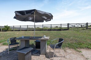 An outdoor seating area with a table, chairs, and a table umbrella.
