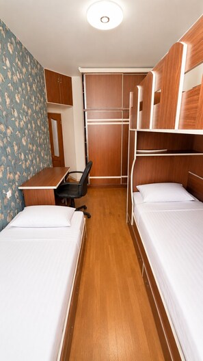 A compact hotel room with bunk beds, a desk, and a chair. - Spacious 2BR Apartment with Balcony (Yerevan)