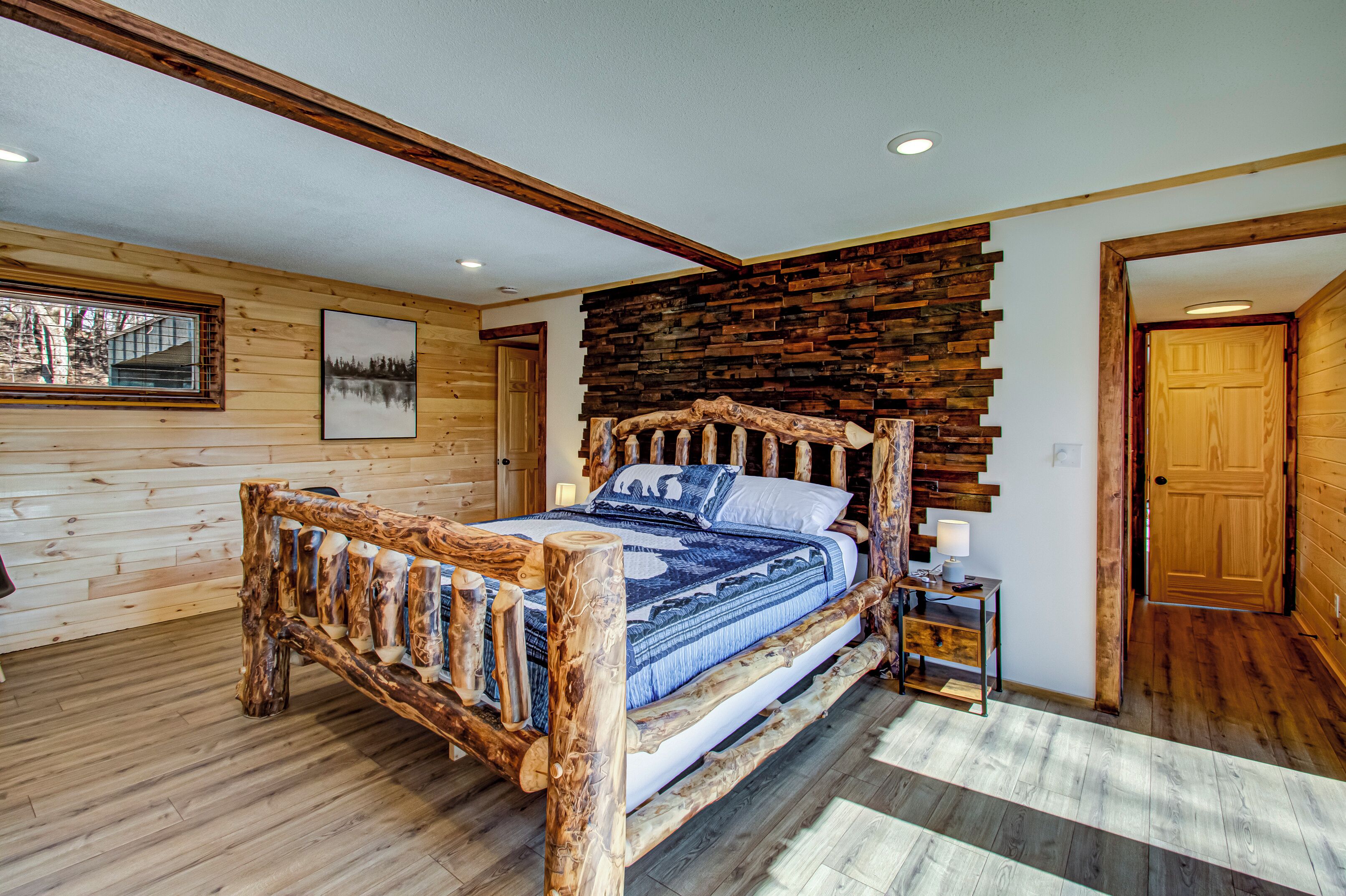 Une chambre à coucher en bois, avec un lit, une table de chevet et un mur orné de panneaux de bois.