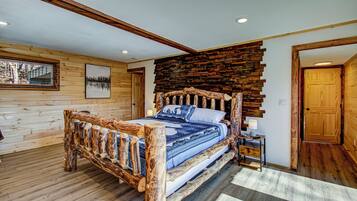 A wooden bedroom with a bed, a nightstand, and a wall with a wooden panel design.