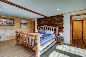 Une chambre à coucher en bois, avec un lit, une table de chevet et un mur orné de panneaux de bois.