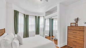Ein Schlafzimmer mit einem Bett, einem Schminktisch und einem Spiegel.
