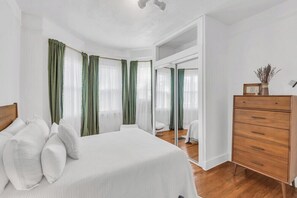 A bedroom with a bed, a dresser, and a mirror. - Zen Retreat in Asbury Park with Patio & Parking (Asbury Park)