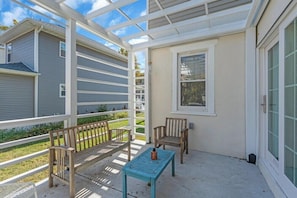 A covered porch with a bench, a table, and a chair. - Zen Retreat in Asbury Park with Patio & Parking (Asbury Park)