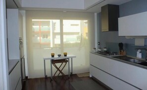 Uma cozinha moderna com área de jantar, janela com vista e armários embutidos.