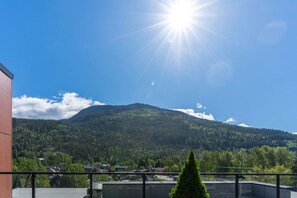 A mountain landscape with a clear sky and a bright sun. - Revelhaus | Boutique Mountain Retreat (Revelstoke)