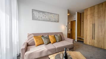 Ein modernes Wohnzimmer mit einer Couch, dekorativen Kissen, einem Wandbild und einem Holzkabinett.