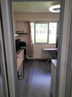 Une petite cuisine avec une fenêtre, une chaise et une table.