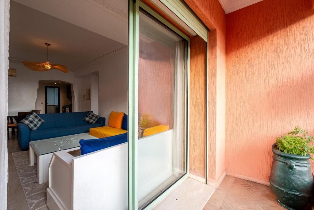 Una sala de estar moderna con un conjunto de sofá, una mesa de centro y un ventanal corredizo que da a un espacio exterior.