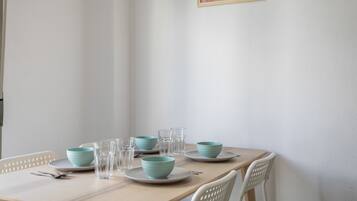 A dining table with plates, bowls, and glasses set for four.