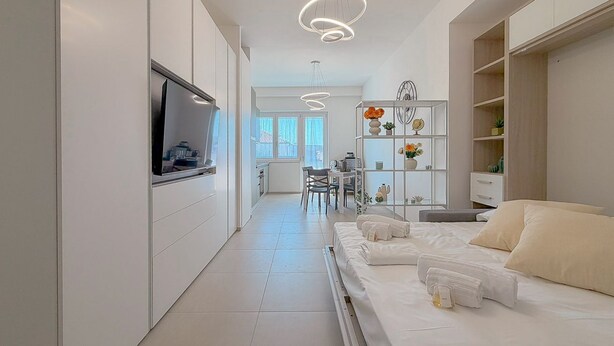A modern hotel room with a bed, a TV, a desk, and a chair. - Bright Studio with A/C and Balcony (Civitanova Marche)