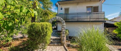 Una casa de dos pisos con un camino de piedra que conduce a la entrada.