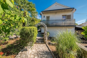A two-story house with a stone pathway leading to the entrance. - Apartment Moderna in Soline (Soline)