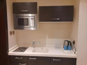 Una cocina con microondas, estufa, fregadero y armarios.