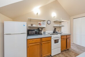 A kitchen with a refrigerator, microwave, stove, and wooden cabinets. - 2 Bedroom Upstairs Apartment in Middle of Nashville! (Nashville)