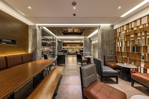 Un interior moderno con zonas de estar, un bar y vistas al área del bar.